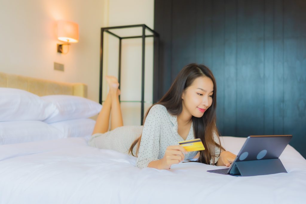Tips for Getting the Best Mattress Deals (2022 Mattress Shopping Guide) 2 portrait beautiful young asian woman use tablet with credit card bed