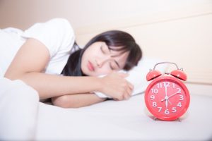 young sleeping woman alarm clock bedroom home